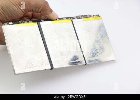 Batteria ai polimeri di litio utilizzata per alimentare i notebook tenuti in mano su uno sfondo bianco Foto Stock