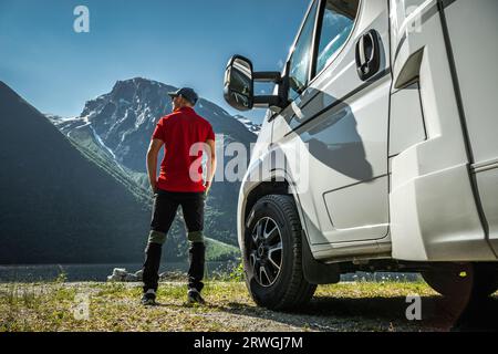 Turista caucasico nei suoi 40 anni e il suo camper Touring di fronte al paesaggio norvegese panoramico Foto Stock