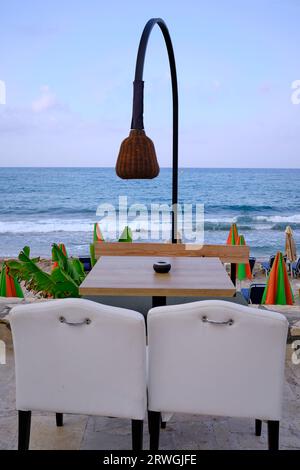 Tavolo del ristorante sulla spiaggia a Limenas Chersonisou, Hersonissos, Grecia Foto Stock