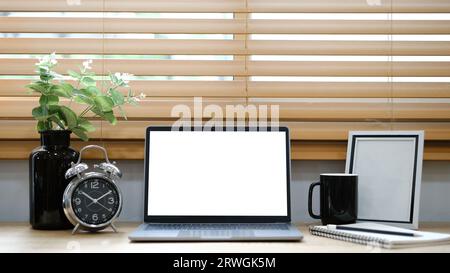 Notebook bianco con schermo vuoto posizionato sul tavolo vicino alla finestra. Foto Stock