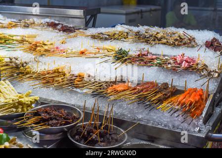 Molti spuntini crudi e frutti di mare nello Street food di Jalan Alor a Kuala Lumpur Foto Stock