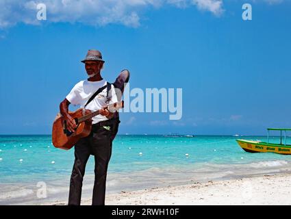 Un giamaicano che suona la chitarra sulla Seven Mile Beach a Negril Foto Stock