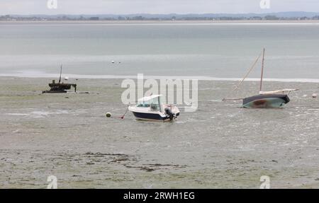 Barche e motoscafi bloccati in Normandia, nel nord della Francia, durante la bassa marea Foto Stock