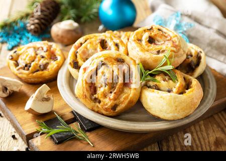 Pizza Rolls sfoglia farcita con prosciutto pancetta, funghi e formaggio sul tavolo di Natale, antipasti italiani. Foto Stock