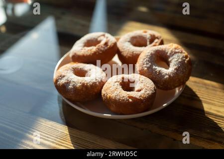 Ciambelle con zucchero in polvere. Cibo delizioso alla luce del sole. Tè dolce. Cibo a tavola. Foto Stock