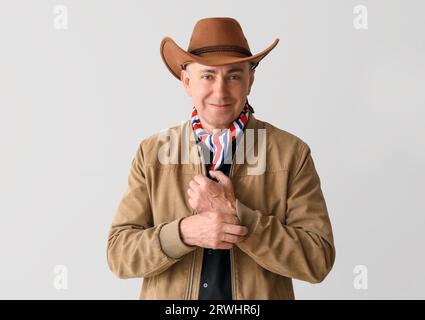 Cowboy maturo su sfondo chiaro Foto Stock