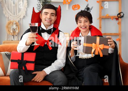 Il bambino e suo padre si sono vestiti per Halloween come vampiri con regali a casa Foto Stock