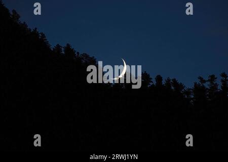 Anantnag, India. 18 settembre 2023. Vista generale della luna a mezzaluna che si innalza sulla montagna nell'area di Kokernag del distretto di Anantnag, a sud di Srinagar Kashmir. (Foto di Faisal Bashir/SOPA Images/Sipa USA) credito: SIPA USA/Alamy Live News Foto Stock