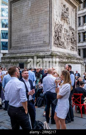I lavoratori in ufficio apprezzano un drink dopo il lavoro vicino al Monumento, alla City di Londra, Londra, Regno Unito. Foto Stock