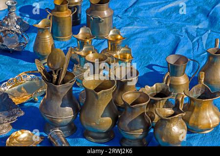 Vecchie caraffe in metallo e ottone vintage vendute all'esterno su un mercato delle pulci Foto Stock