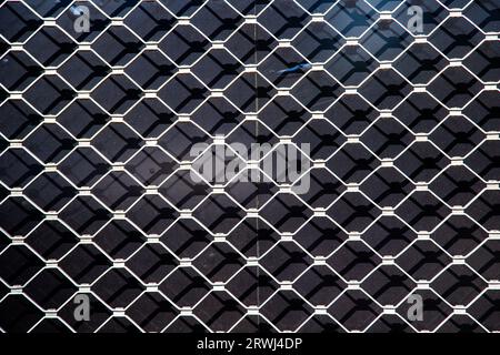 la trama armonica della griglia metallica nel dettaglio fornisce uno sfondo armonico che simboleggia la tecnica moderna Foto Stock