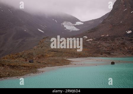 Unna Raitastugan Mountain Hut sul lato di un lago glaciale all'inizio di settembre, Lapponia, Svezia Foto Stock