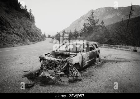 Un'auto bruciata sul lato della Duffy Lake Road tra Pemberton e Lillooet BC. Gli incendi dei veicoli sono comuni sulle ripide e tortuose autostrade. Nero Foto Stock