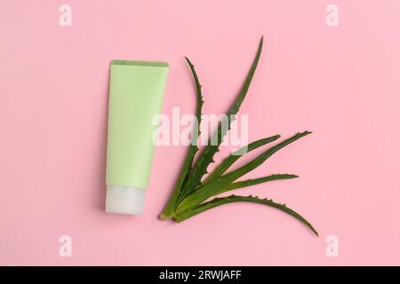 Tubo di dentifricio e aloe fresca su sfondo rosa, disteso Foto Stock