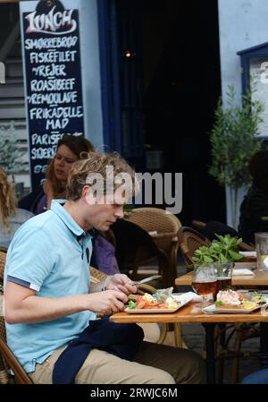 Turista che si gode il tradizionale Smørrebrød danese nei ristoranti di Nyhavn, Copenaghen, Danimarca. Foto Stock