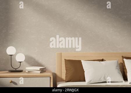 Un'intima camera da letto dal design minimalista scandinavo con un letto con comodi cuscini, una lampada da tavolo minimale e libri su un cassetto accanto al letto e wal beige Foto Stock