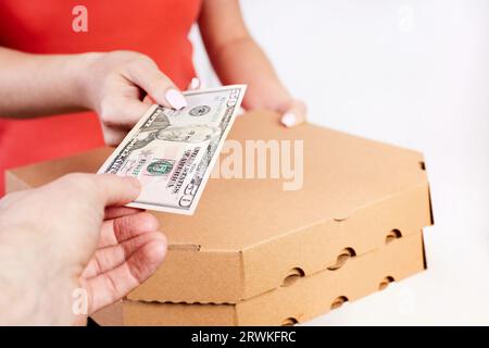 Il cliente paga la pizza al corriere in contanti Foto Stock