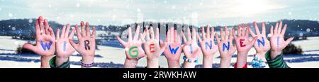 Children Hands Building Word Wir Gewinnen significa vincere, sfondo invernale. Foto Stock