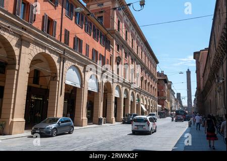 La fila di negozi e negozi in via Ugo Bassi sotto il portico coperto a soffitto alto o colonnati con una struttura del tetto su una passerella sostenuta Foto Stock