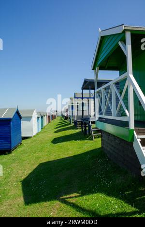 Piccole case sulla spiaggia di Tankerton sulle pendici di Tankerton sul lungomare di Whitstable, Kent, Regno Unito. Capanne in legno rialzate con vista mare nelle giornate di sole blu Foto Stock