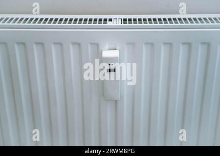 vista ravvicinata del radiatore dell'appartamento con il termometro intelligente. Crisi energetica in Europa. Immagine con messa a fuoco selettiva Foto Stock