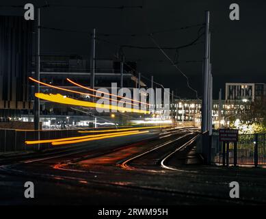 Tram Light Trail di notte in un ambiente urbano Foto Stock