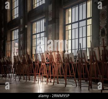 L'artista solitario ha molti quadri montati su cavalletti in una mostra in una grande sala decorata con molte grandi finestre alla stazione di Sao Bento Foto Stock