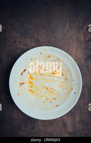 Piastra vuota sporca. Piatto disordinato su un tavolo di legno. Vista dall'alto Foto Stock