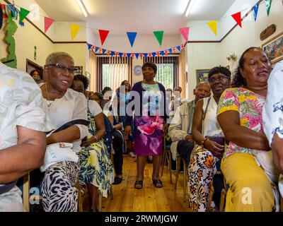 I visitatori si riuniscono presso la Jamaica Society di Leeds, per onorare il 75° anniversario dell'arrivo della HMT Empire Windrush nel Regno Unito. Foto Stock