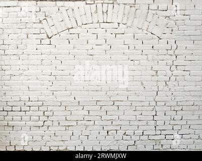 Sfondo bianco della parete con arco in mattoni antichi Foto Stock