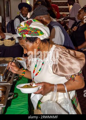 I visitatori si riuniscono presso la Jamaica Society di Leeds, per onorare il 75° anniversario dell'arrivo della HMT Empire Windrush nel Regno Unito. Foto Stock