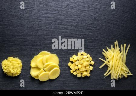 vista dall'alto di mucchi di verdure radici di zenzero tritato strisce, schiacciato, grattugiato e macinato su fondo di pietra ardesia nera Foto Stock