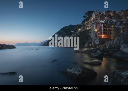 Crepuscolo blu sul villaggio di pescatori di Riomaggiore. Paesaggio marino nel Parco Nazionale delle cinque Terre, provincia di la Spezia, regione Liguria, Italia, Europa. Foto Stock