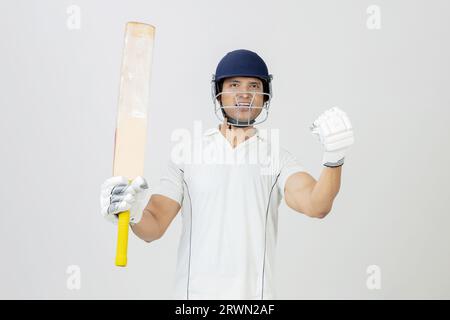 Cricket in piena espressione di gioia che urla verso la telecamera, uomo in abito da cricket che urla di gioia e celebra la vittoria Foto Stock