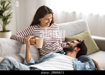 Dolce coppia millenaria indiana coccolarsi a casa, fare conversazione Foto Stock