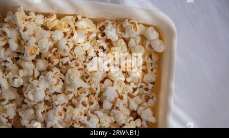 popcorn bianchi fatti in casa in una ciotola bianca, da vicino. Una ciotola di popcorn appena sfornati Foto Stock