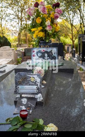 Fiori e foto collocate sulla tomba della famosa cantante Edith Piaf nel cimitero di Pere Lachaise a Parigi, in Francia. Piaf è sepolta con suo padre, Lou Foto Stock