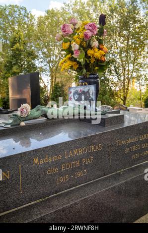 Fiori e foto collocate sulla tomba della famosa cantante Edith Piaf nel cimitero di Pere Lachaise a Parigi, in Francia. Piaf è sepolta con suo padre, Lou Foto Stock