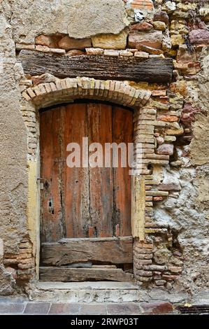 Porta di legno distrutta di una casa antica Foto Stock