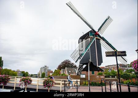 Leiden, Paesi Bassi. 13 settembre 2023. Uno studente olandese passa vicino a un vecchio mulino con la sua bici. Dopo un fine settimana che ha stabilito un nuovo record di calore nel paese, è finalmente arrivato il clima autunnale, con forti piogge, basse temperature sotto i 20 gradi e giornate nuvolose. (Immagine di credito: © Ana Fernandez/SOPA Images via ZUMA Press Wire) SOLO USO EDITORIALE! Non per USO commerciale! Foto Stock