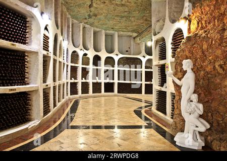 Bottiglie di vino conservate presso le antiche gallerie sotterranee di pietra calcarea della cantina Cricova a Cricova, Moldavia Foto Stock