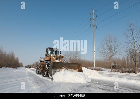 CONTEA DI LUANNAN, Cina - 14 febbraio 2022: I gestori del traffico stradale guidano gli elevatori per liberare la neve sull'autostrada e garantire che l'autostrada non sia in funzione Foto Stock