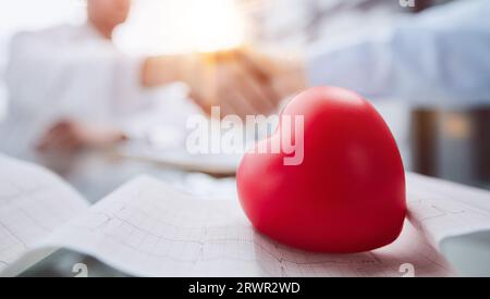 il cuore si trova sul tavolo sullo sfondo dei cardiologi sullo sfondo Foto Stock