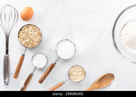 Diversi utensili da forno con ingredienti su un tavolo in marmo bianco. Foto Stock