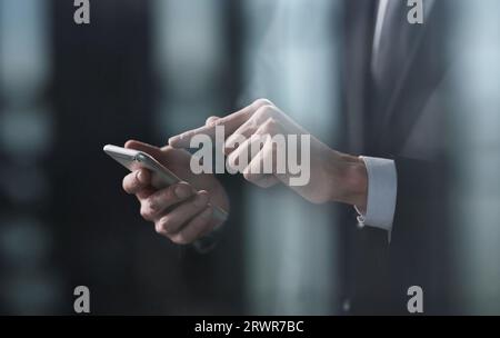 Vista laterale della mano di un uomo preme un dito su uno smartphone. Simulazione per il tuo progetto, copia spazio. Foto Stock