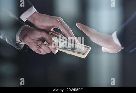 La mano di un uomo in un vestito nero tiene fuori un wad di soldi, che rifiuta. Concetto di Giornata Mondiale contro la corruzione Foto Stock