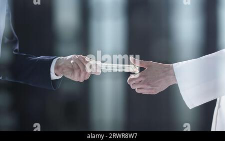 Uomo che offre un lotto di banconote da cento dollari. Mani da vicino. Foto Stock