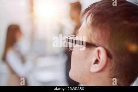 Colpo di testa, ritratto di un dipendente di sesso maschile Millennial che guarda lontano dall'ufficio di coworking Foto Stock