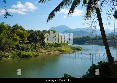 Laos: Un ponte di bambù sul fiume Nam Khan, Luang Prabang. Luang Prabang era precedentemente la capitale di un regno con lo stesso nome. Fino all'acquisizione comunista nel 1975, fu la capitale reale e sede del governo del Regno del Laos. La città è oggi un sito patrimonio dell'umanità dell'UNESCO. Foto Stock