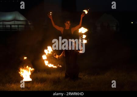 REGIONE DI TVER, RUSSIA - 21 LUGLIO 2023: Due ragazze ballano con il fuoco. Un frammento dello spettacolo di fuoco sullo storico festival "Epic Coast-2023" Foto Stock